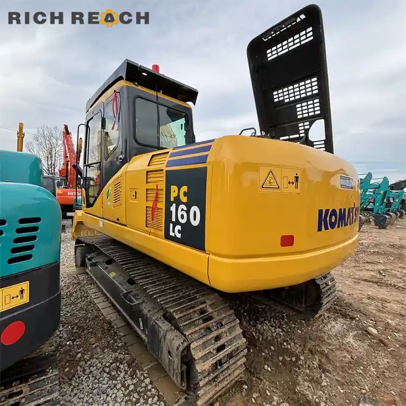 Used Komatsu PC160LC excavator cab interior with armrest controls, low-hour machine, stability enhanced, priced in USD