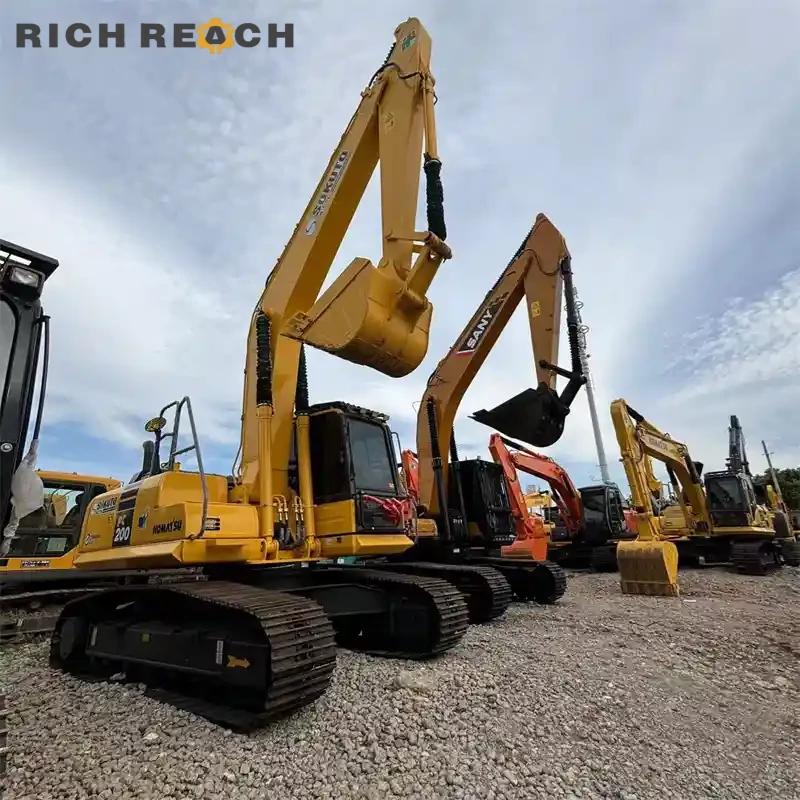 Used Komatsu PC200 excavator breaking concrete with hydraulic hammer attachment