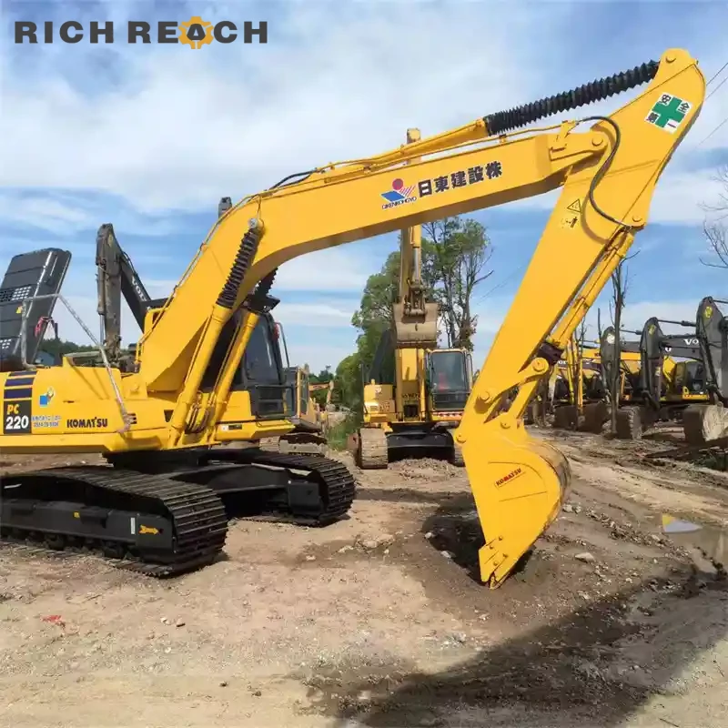 Used Komatsu PC220 excavator grading a parking lot