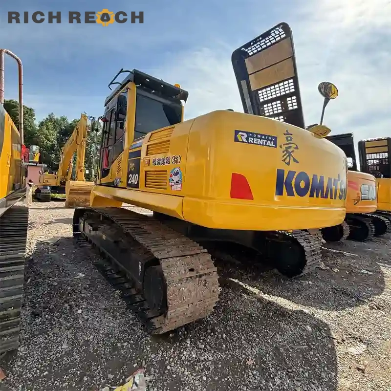 High-back suspension seat, pilot joysticks and interior controls of a used Komatsu PC240 excavator cab