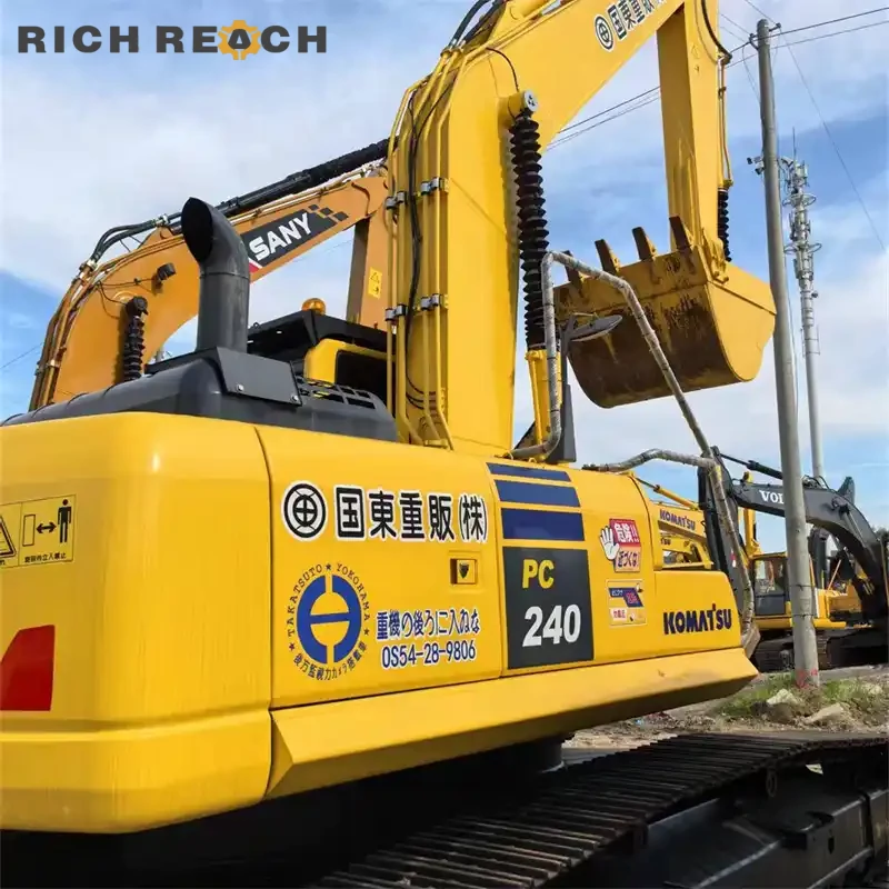 Rear three-quarter view of a used Komatsu PC240 crawler excavator showing solid undercarriage and boom