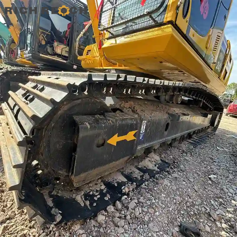 Track guard, carrier roller and track link assembly on a used Komatsu PC240 with low wear