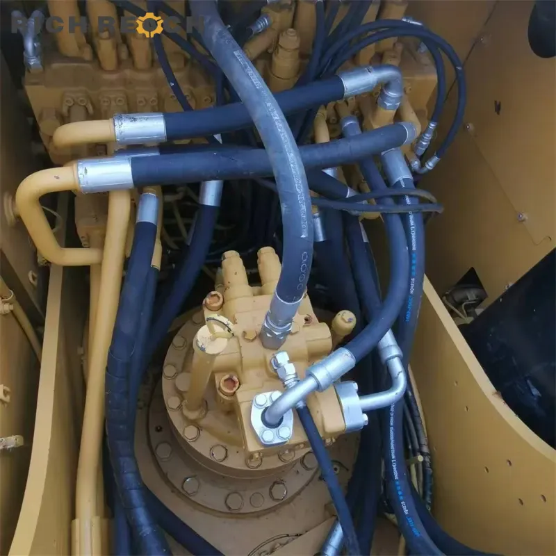 Top-down view of the hydraulic center swivel joint, control valve block, and complex high-pressure hoses on a Caterpillar 320D2 excavator.