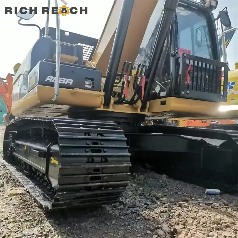 Low-angle close-up of the steel track assembly, undercarriage frame, and operator cabin on a Caterpillar 320D2 REGA excavator.