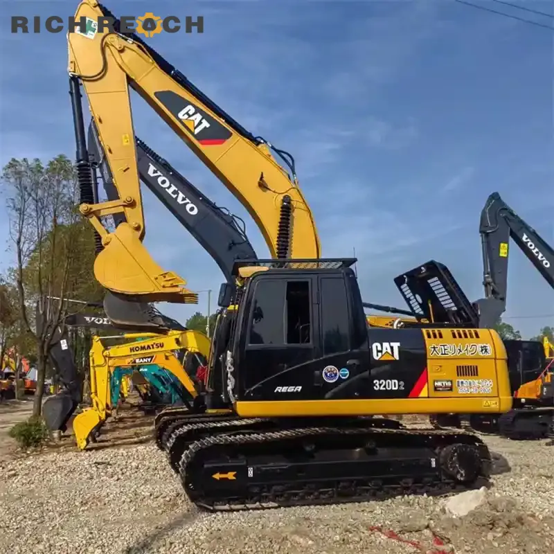 Full side view of a yellow and black Caterpillar 320D2 REGA crawler excavator parked on a machinery lot under a clear blue sky.