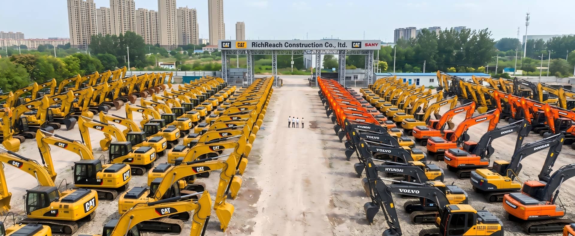 An aerial drone view of a large-scale excavator fleet yard at RichReach Construction Co., Ltd., showcasing rows of heavy machinery including Doosan, CAT, Sany, Hyundai, and Volvo excavators.